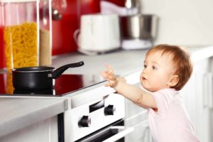 Baby reaching for pot on stove