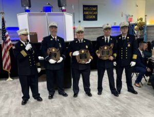 5 firefighters dressed in blue with awards